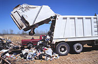 Photo of garbage truck with back half open